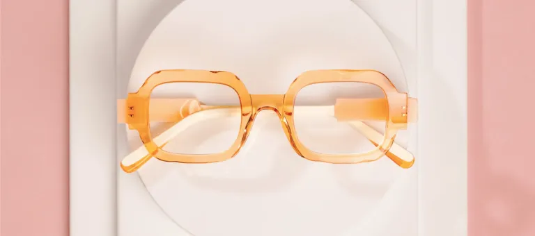 Pomarańczowe transparentne oprawki Anne et Valentin na pastelowym tle